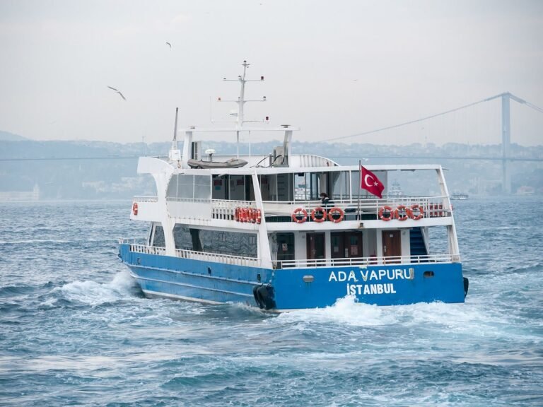 A passenger ferry crossing the Bosphorus in Istanbul, with a suspension bridge in the distance