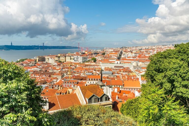 Terracotta rooftops of Lisbon seen from São Jorge Castle, with the Tagus River beyond